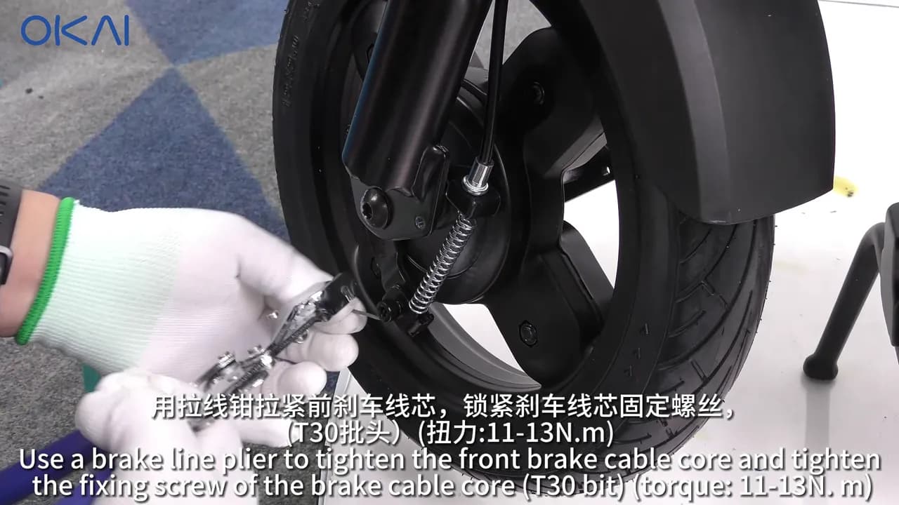 Technician adjusting the OKAI ES400A front brake cable