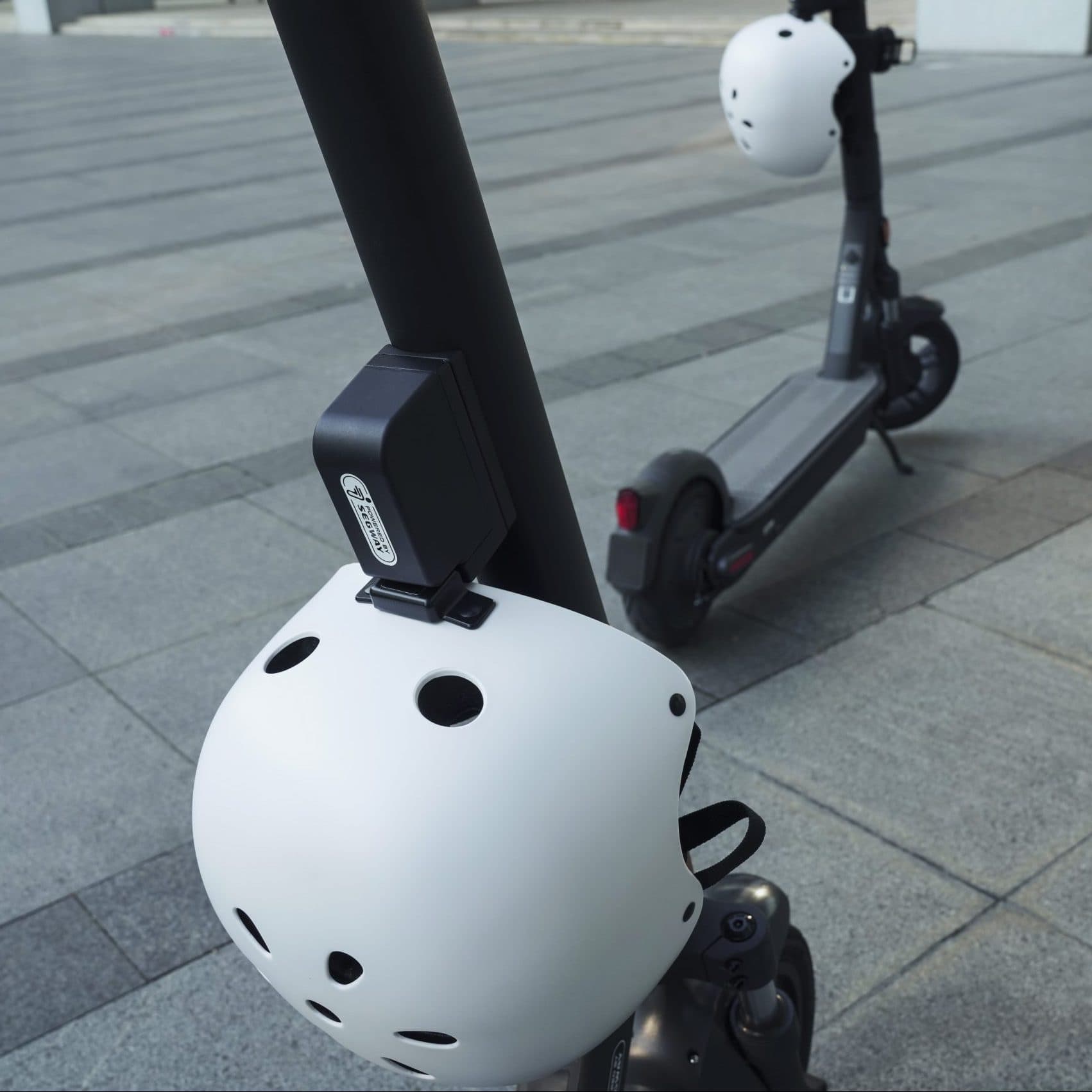 Segway Helmet Lock Kit securing a white helmet to a shared scooter stem