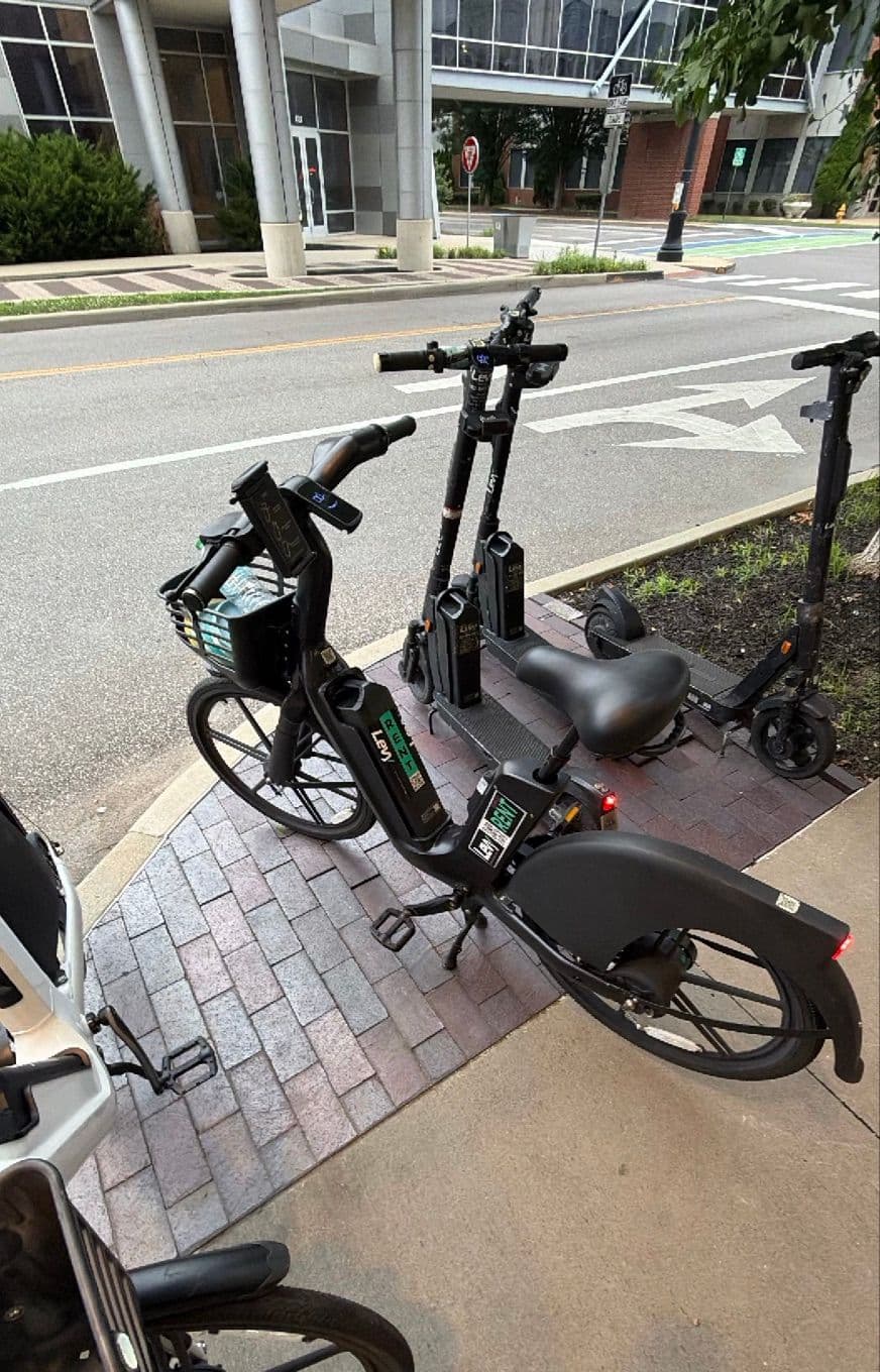 An e-bike parked neatly in a designated curbside bike corral